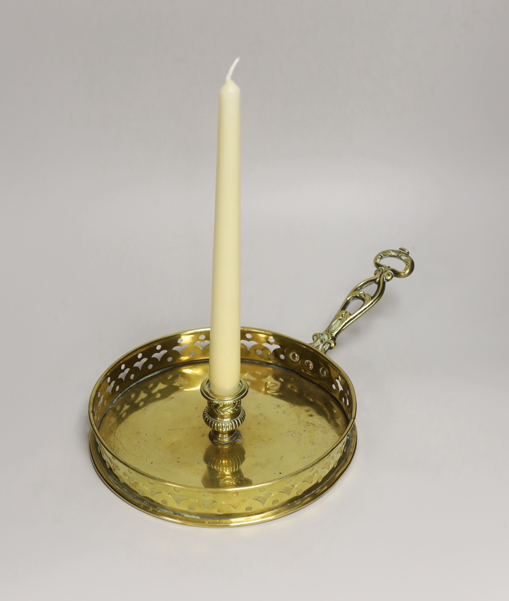 A brass chamberstick, with a wide drip pan and pierced galleried border, 32cm wide